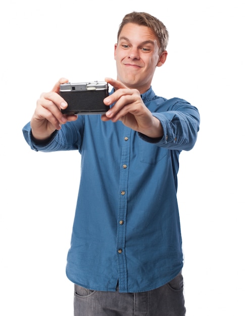 Hombre haciendose un selfie con una cámara antigua