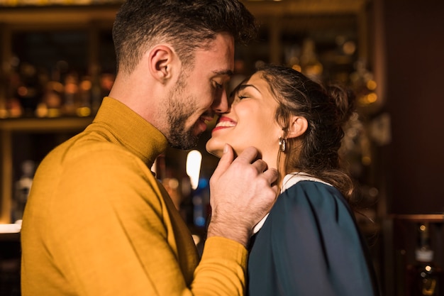 Hombre hermoso que besa a la mujer alegre