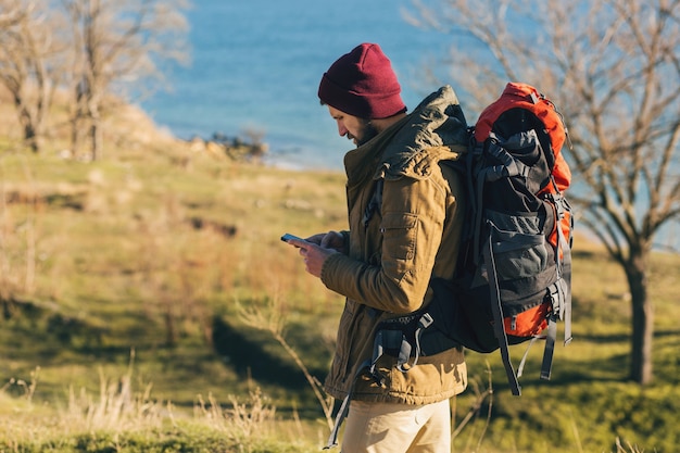 Hombre hipster viajando con mochila con sombrero y chaqueta caliente