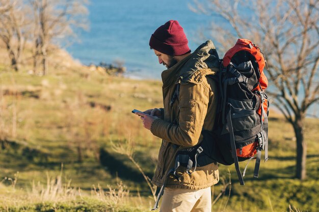 Hombre hipster viajando con mochila con sombrero y chaqueta caliente