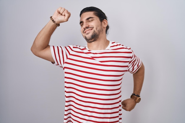 Foto gratuita hombre hispano con el pelo largo parado sobre un fondo aislado que se extiende hacia atrás cansado y relajado, somnoliento y bostezando temprano en la mañana