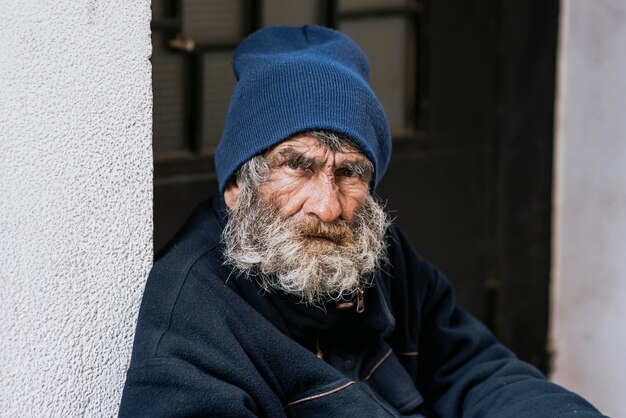 Hombre sin hogar barbudo en la puerta