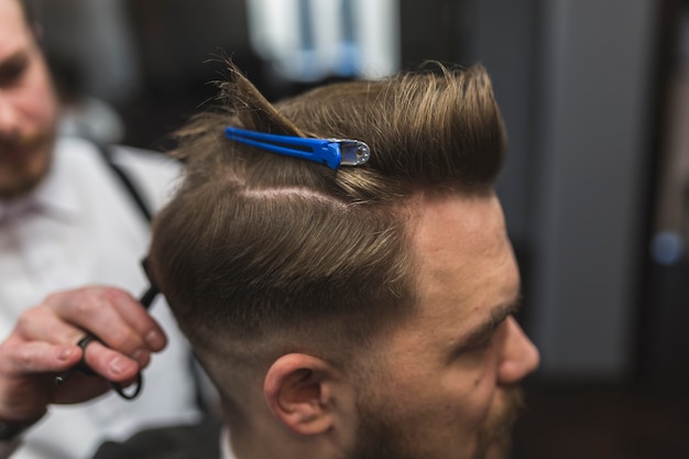 Hombre con horquilla teniendo corte de pelo