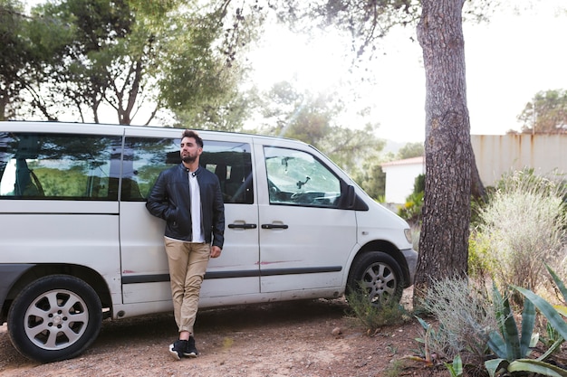 Hombre inclinado frente a coche