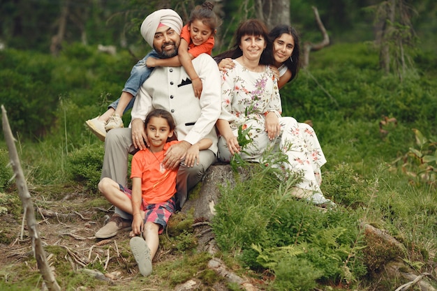 Hombre indio en un bosque. Hombre con un turbante tradicional. Familia internacional en un bosque de verano.