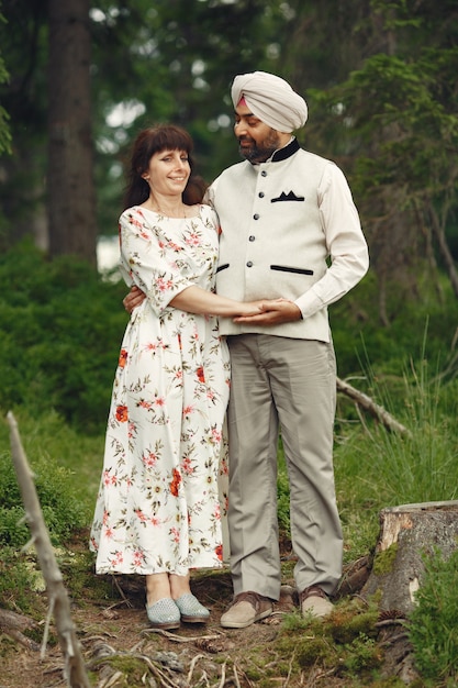 Hombre indio en un bosque. Hombre con un turbante tradicional. Familia internacional en un bosque de verano.