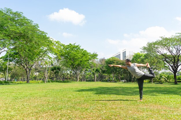 Hombre indio haciendo señor de la danza plantean al aire libre en el parque de la ciudad de verano con árboles