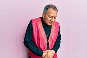 Foto gratuita hombre indio de mediana edad vestido con ropa tradicional india con la mano en el estómago porque indigestión enfermedad dolorosa sensación de malestar concepto de dolor