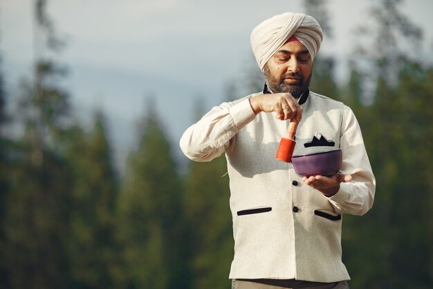 Hombre indio en una montaña. Hombre con un turbante tradicional. Hinduista con cosas especiales para rituales.