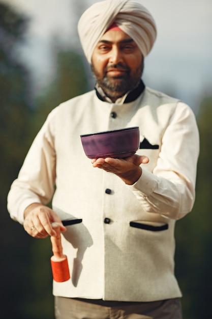 Hombre indio en una montaña. Hombre con un turbante tradicional. Hinduista con cosas especiales para rituales.