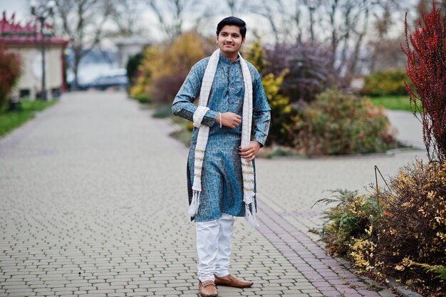 Hombre indio vestido con ropa tradicional con bufanda blanca posada al aire libre