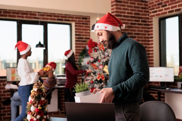 Foto gratuita un hombre infeliz fue despedido en la víspera de navidad, se sintió deprimido y molesto después de ser despedido de su trabajo comercial. perder trabajo y estar desempleado el día de navidad, fracaso profesional en el lugar de trabajo festivo.