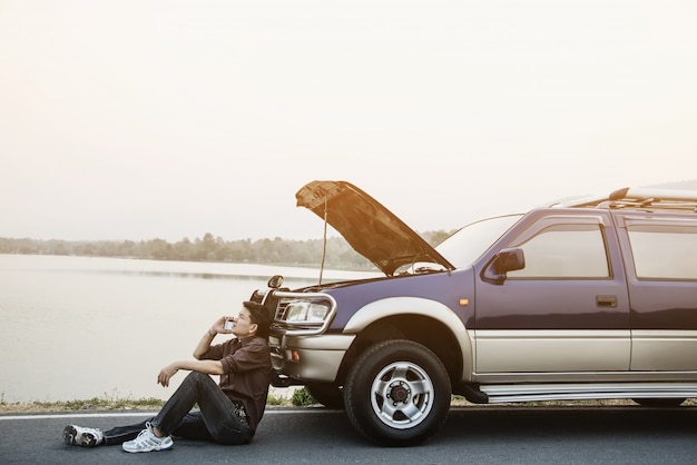 Foto gratuita el hombre intenta solucionar un problema de motor de automóvil en una carretera local