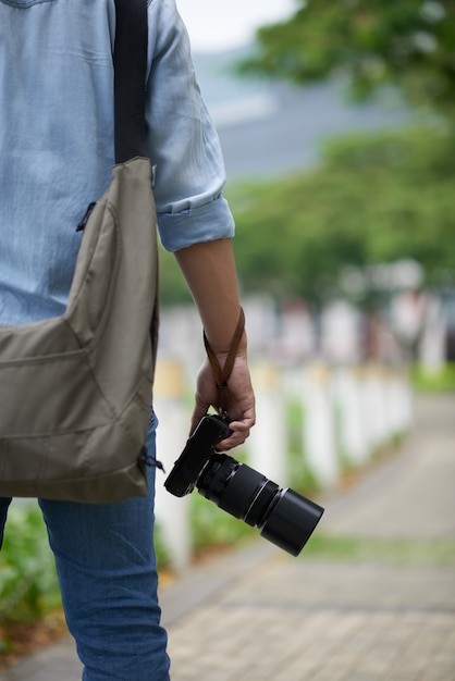 Hombre irreconocible con cámara de fotos profesional de pie en el parque