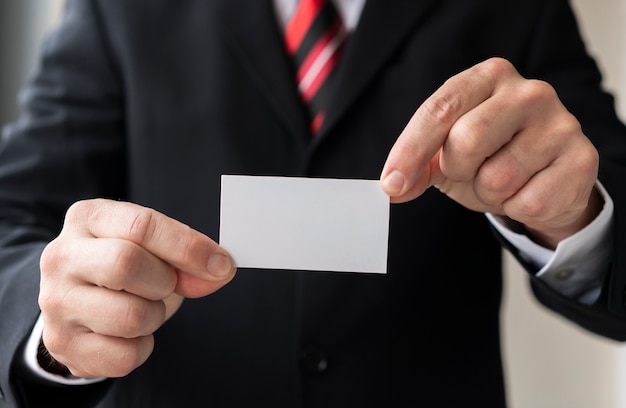 Hombre irreconocible con tarjeta en blanco