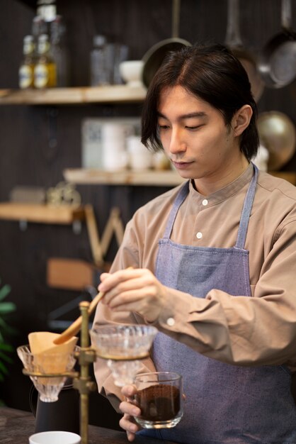 Hombre japonés haciendo café en un restaurante.