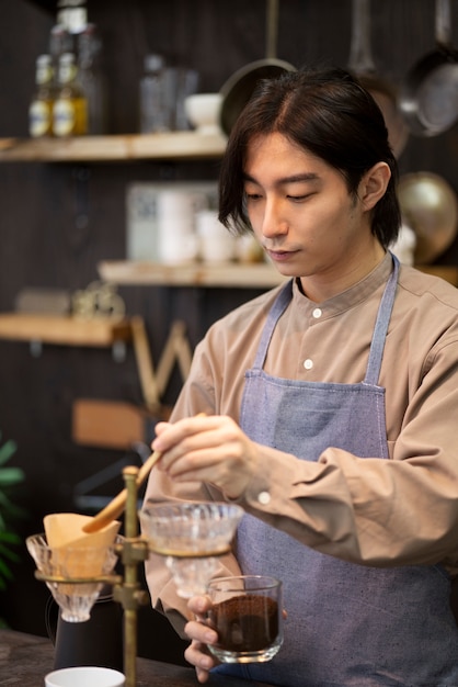 Hombre japonés haciendo café en un restaurante.