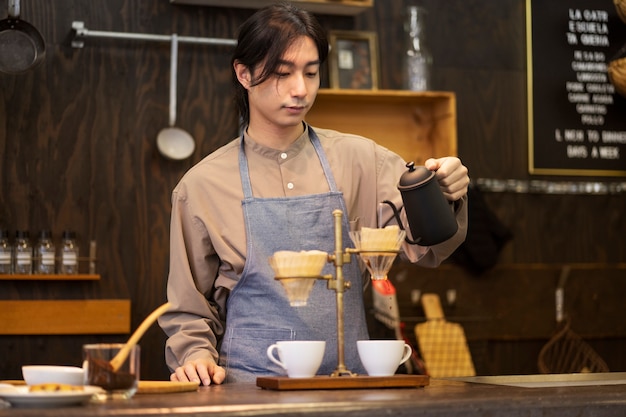 Hombre japonés haciendo café en un restaurante.