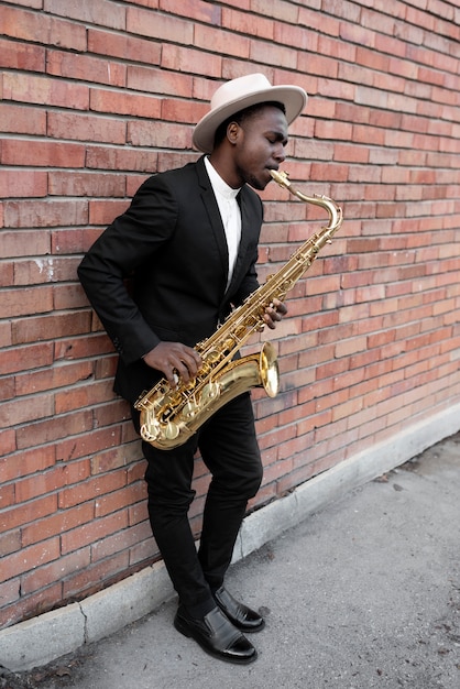 Hombre de jazz de tiro completo tocando el saxofón