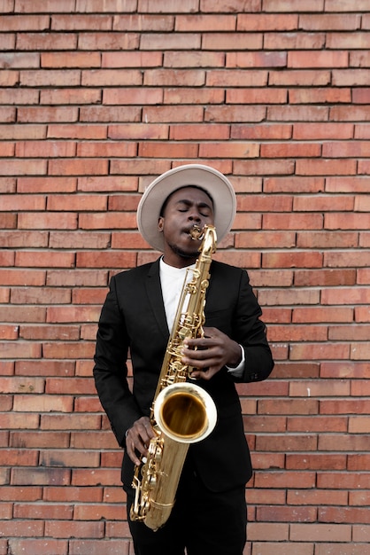 Foto gratuita hombre de jazz de tiro medio tocando el saxofón