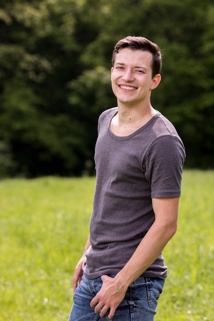 Hombre joven alegre que presenta en naturaleza