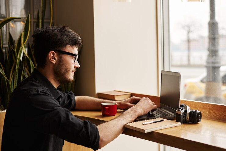 Foto gratuito hombre joven en anteojos busca ideas de cuidado de bebé en internet