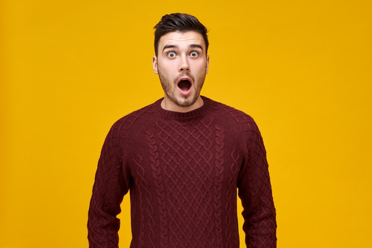 Foto gratuito hombre joven asombrado divertido con mirada de pánico, asustado de llegar tarde a las ventas, manteniendo la boca abierta, no puede creer lo que ve