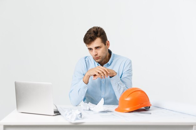 Hombre joven atractivo ingeniero sentirse cansado en el lugar de trabajo.