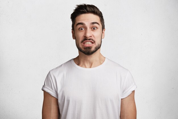 Hombre joven con barba y camiseta blanca