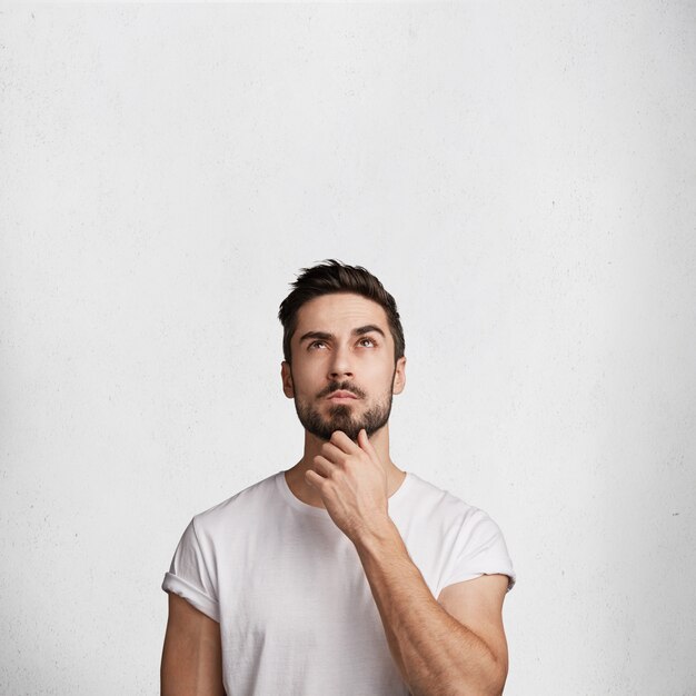 Hombre joven con barba y camiseta blanca