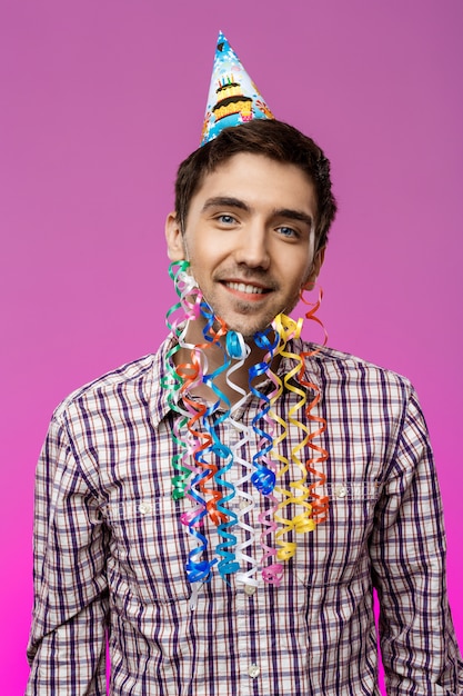 Foto gratuita hombre joven con barba falsa sonriendo en la fiesta de cumpleaños.