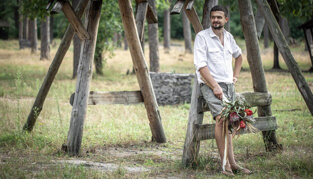 Hombre joven con una camisa blanca con un ramo de flores exóticas, concepto de citas.