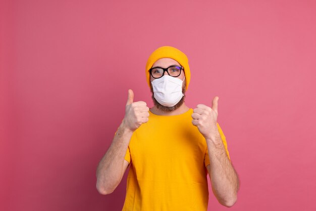 Hombre joven caucásico en gafas con máscara médica de un solo uso para prevenir infecciones, enfermedades respiratorias como la gripe