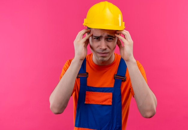 Foto gratuita hombre joven constructor vestido con uniforme de construcción y casco de seguridad está harto