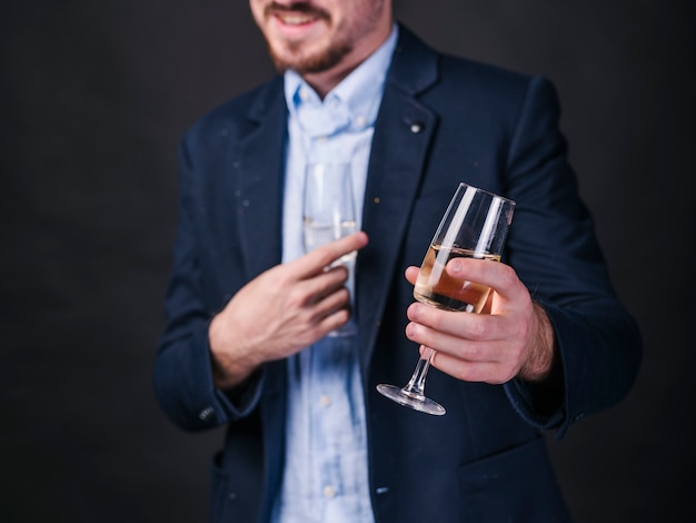 Hombre joven con copas de champán en las manos
