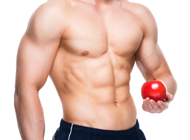 Hombre joven con cuerpo perfecto sosteniendo manzana roja en su mano