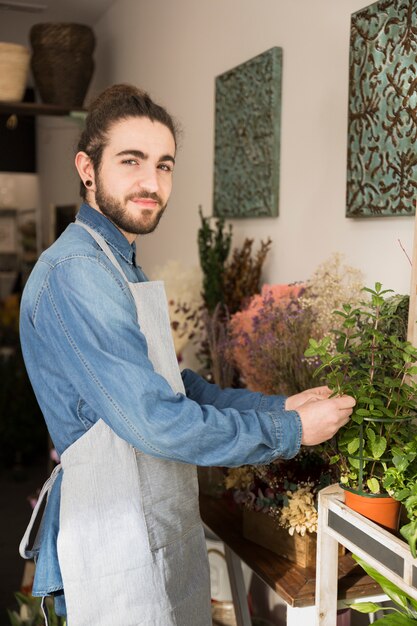 Hombre joven cuidando de la planta en la floristería