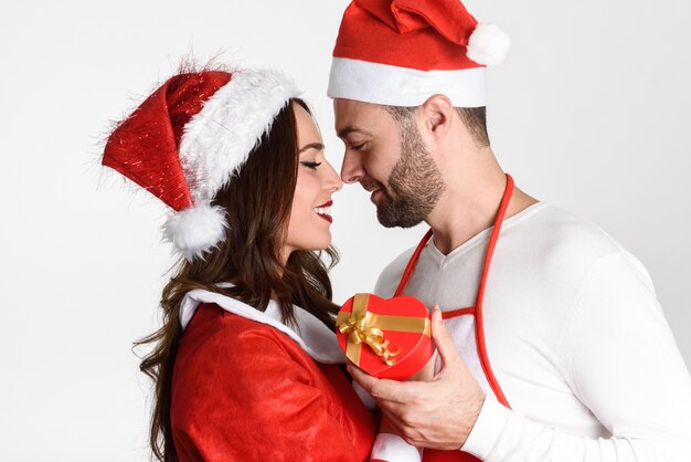 Hombre joven dando un regalo de navidad a su mujer