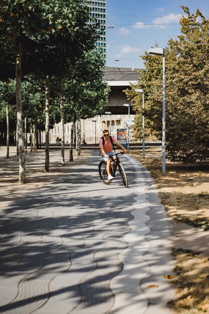 Hombre joven de los deportes en una bicicleta en una ciudad europea. El deporte en entornos urbanos.