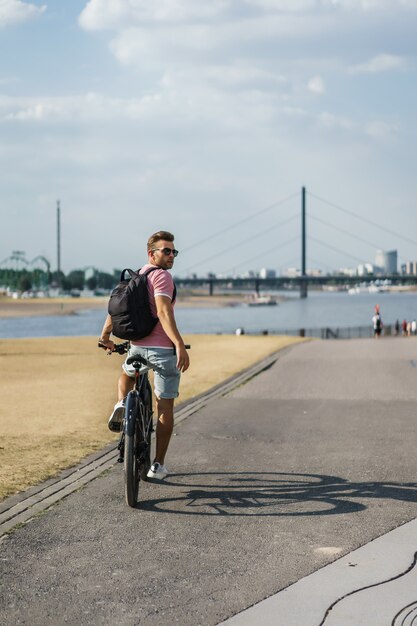 Hombre joven de los deportes en una bicicleta en una ciudad europea. El deporte en entornos urbanos.