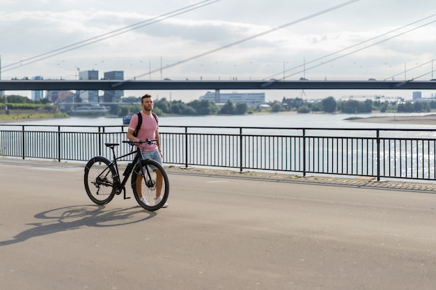 Hombre joven de los deportes en una bicicleta en una ciudad europea. El deporte en entornos urbanos.