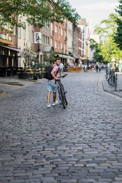 Hombre joven de los deportes en una bicicleta en una ciudad europea. El deporte en entornos urbanos.