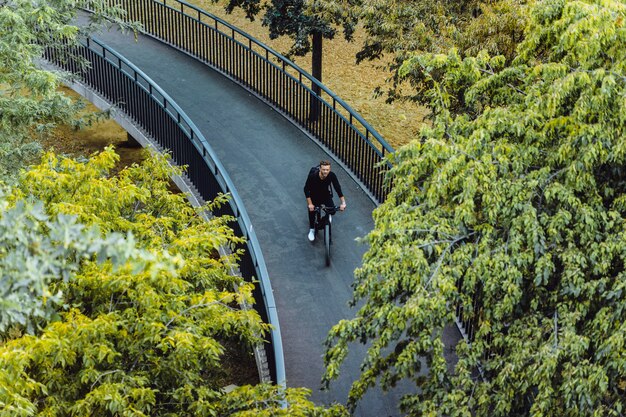 Hombre joven de los deportes en una bicicleta en una ciudad europea. El deporte en entornos urbanos.