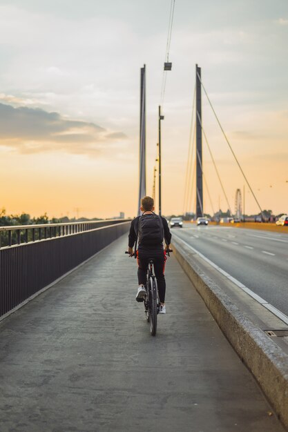 Hombre joven de los deportes en una bicicleta en una ciudad europea. El deporte en entornos urbanos.