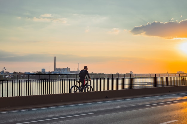 Hombre joven de los deportes en una bicicleta en una ciudad europea. El deporte en entornos urbanos.