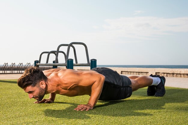 Hombre joven entrenamiento flexiones de brazos