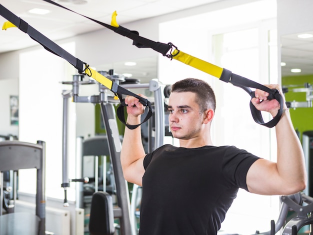 Foto gratuita hombre joven entrenando en el gimnasio