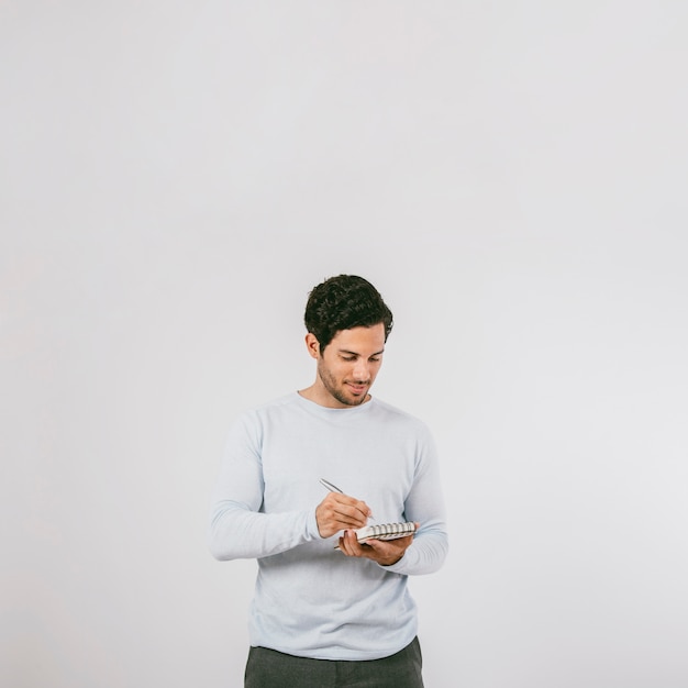 Hombre joven escribiendo en su libreta