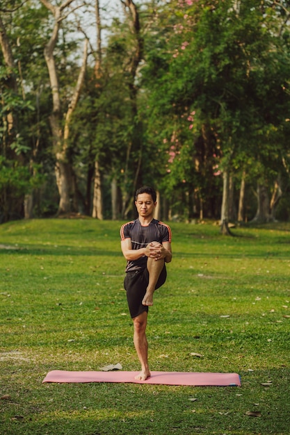 Hombre joven estirando las piernas antes del yoga