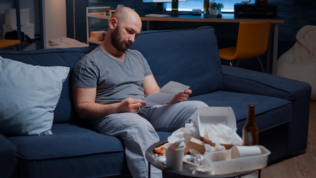 Hombre joven estresado frustrado confundido leyendo la carta